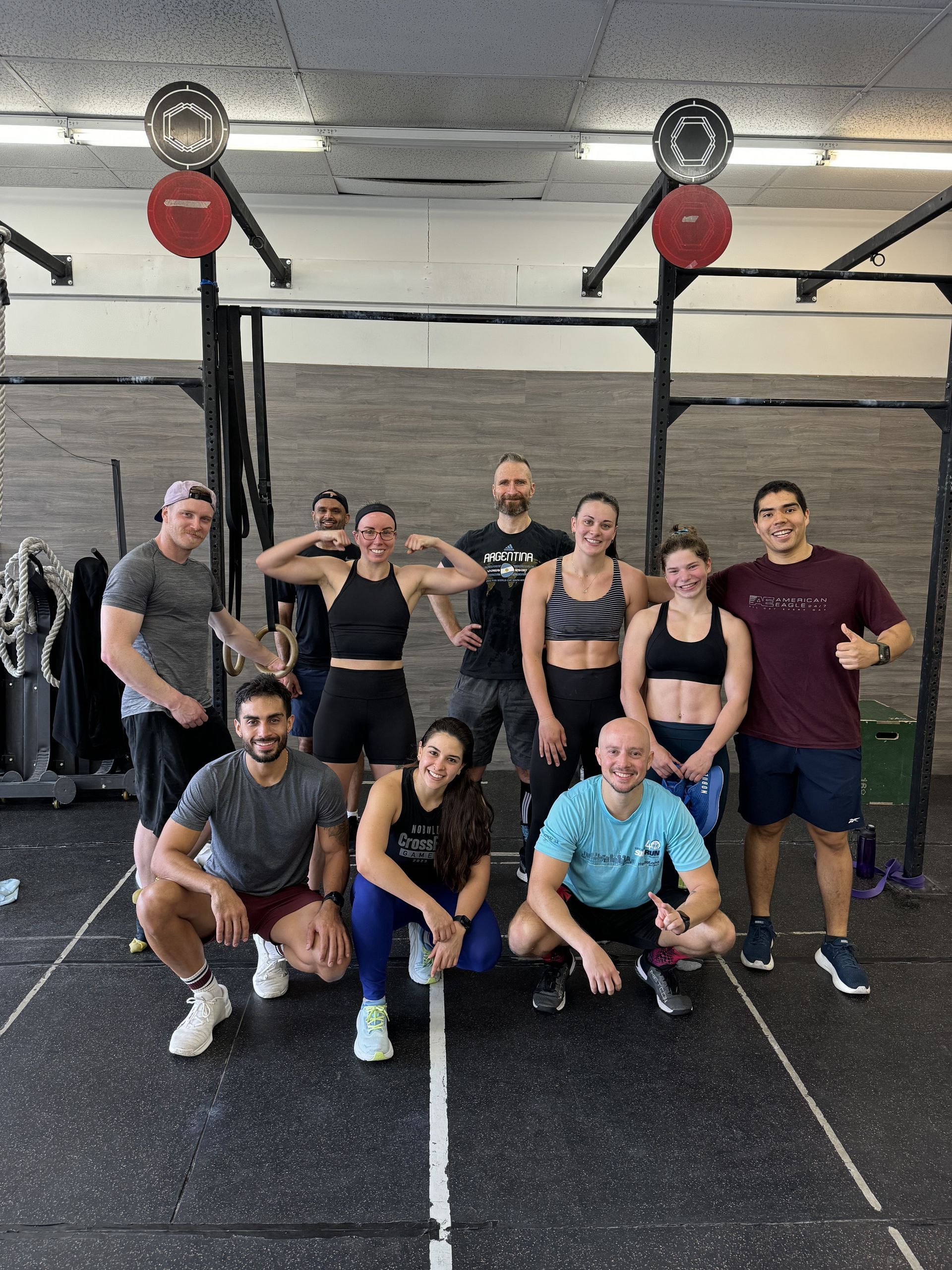 A group of people are posing for a picture in a gym.